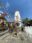 Buddhist stupa surrounded by colorful prayer flags and stone carvings in a temple area.